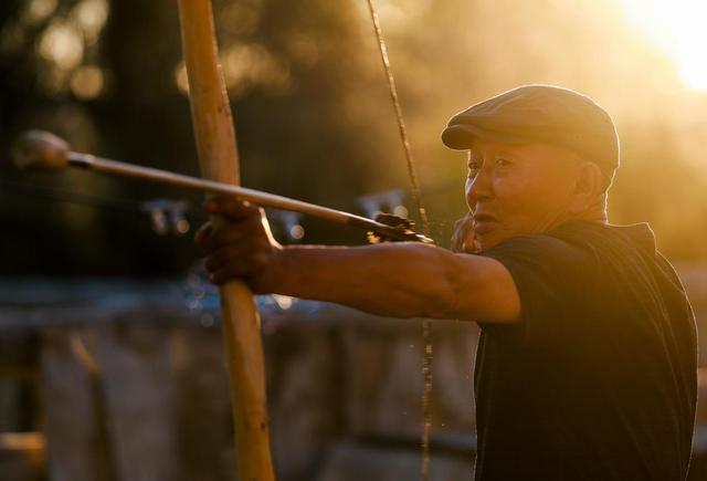 铁木尔加甫试用刚做好的弓箭（5月22日摄）。新华社记者 王菲 摄
