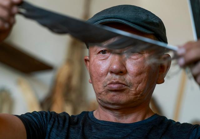 铁木尔加甫在工作室内挑选做箭的羽毛（5月22日摄）。新华社记者 王菲 摄