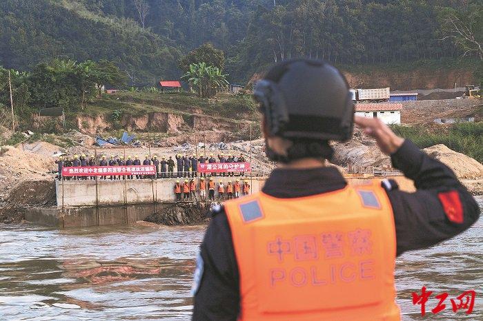 2024年12月24日,湄公河,老挝沿岸施工现场工人向联合巡逻执法编队打招呼,中国警察敬礼回应。