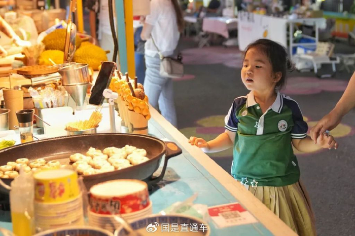 🔹6月13日，在北京丰台花街夜市，摊位的食物吸引小朋友。中新社记者 张祥毅 摄
