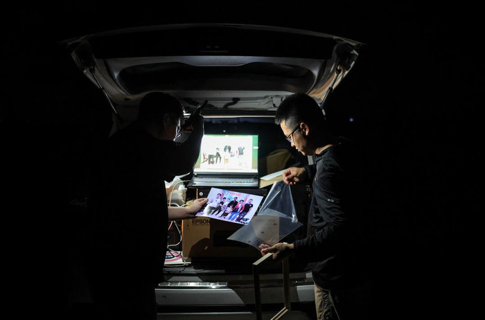 夜色下，记者为张岭、王喜红以及朱建新一家打印了合影照片