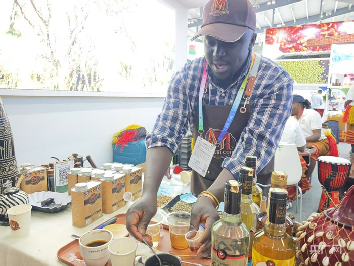 来自非洲乌干达的参展商在为观众制作试饮咖啡（央广网记者杨清  摄）