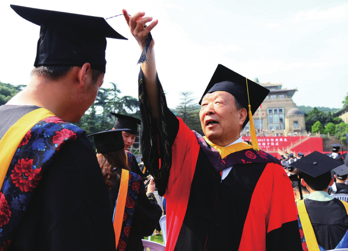 李德仁（右）在武汉大学毕业典礼上为取得学位的毕业生拨穗
