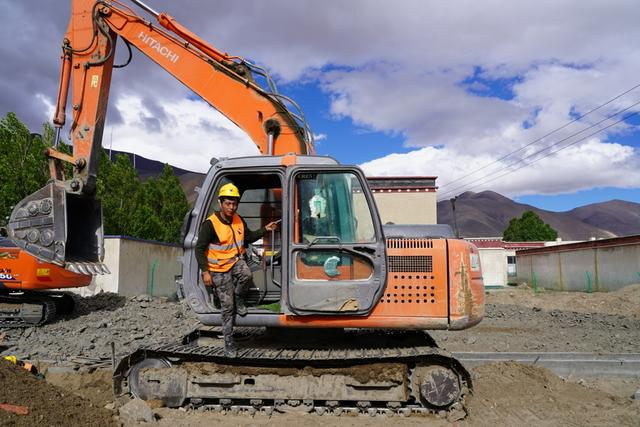 森嘎村村民扎西在重建项目中开挖掘机。 上海援藏干部葛永铭 摄