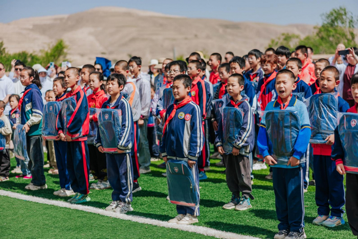 图片信息:孩子们紧紧抱着新捐赠的书包,脸上绽放出幸福而温暖的笑容,内心犹如盛开了绚烂多彩的希望之花。