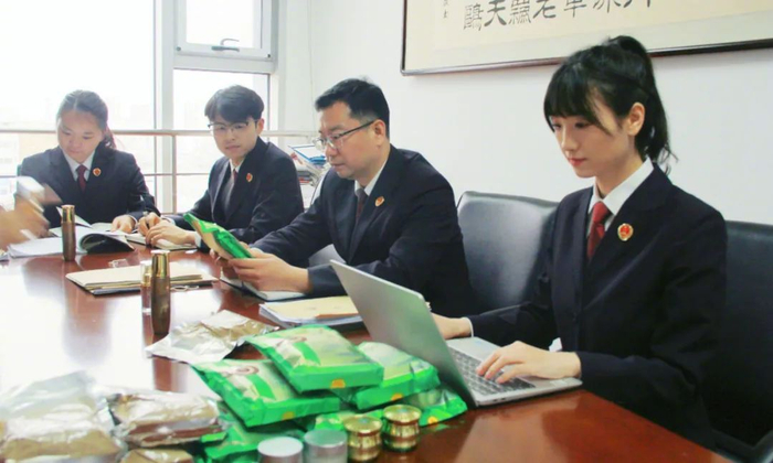 2024年12月，办案组查看涉案物品、讨论案情。