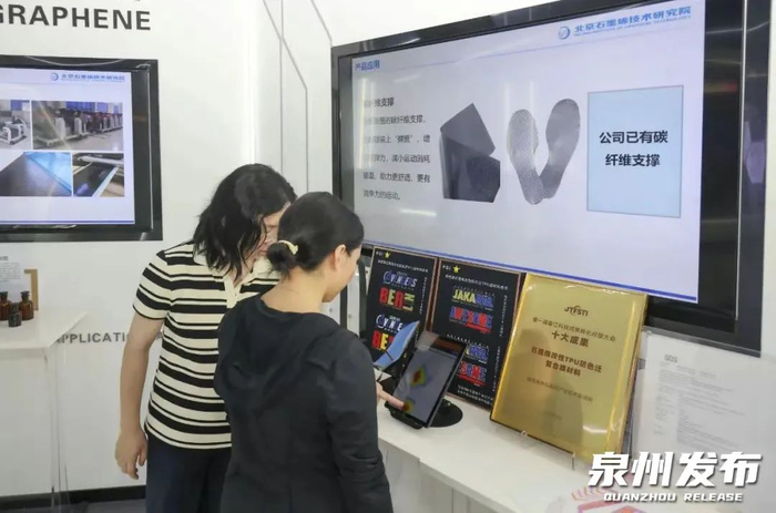 福建海峡石墨烯产业技术研究院院长罗圭纳（左）在介绍石墨烯柔性压力传感器的应用场景。