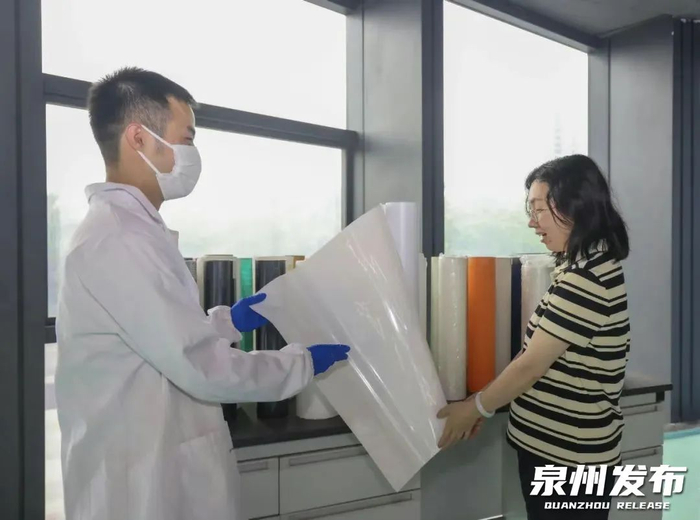 福建海峡石墨烯产业技术研究院院长罗圭纳（右）介绍TPU防色迁刻字膜产品。（泉州晚报社融媒体记者郑银杰 摄）