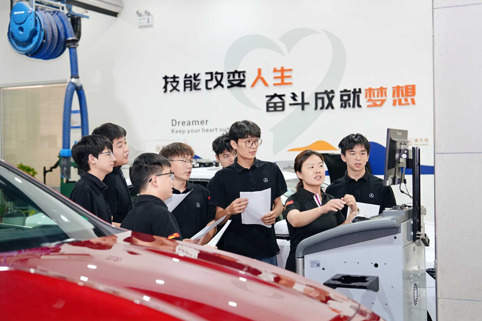 汽车综合实训中心，教师正带着学生实训。