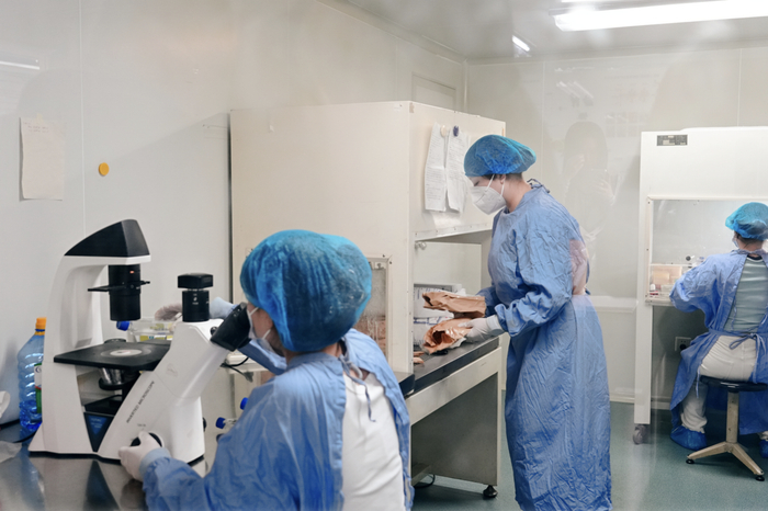 在生命健康研究院无菌室实验室做实验的学生。