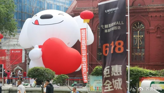 京东的标志玩偶竖立在哈尔滨革新农贸市场周边的天主教堂 / 受访者供图