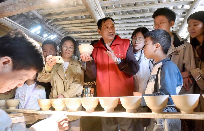 江西景德镇,志愿服务者正向游客讲述陶瓷制作工艺、技艺等陶瓷文化。