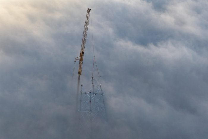 在钟祥南牵引站220千伏外部供电工程现场，建设人员正在紧锣密鼓组建汉江跨越塔。