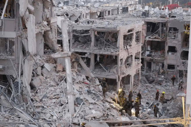 6月15日，在以色列特拉维夫南部的巴特亚姆地区，救援人员在遭伊朗导弹袭击损毁的建筑中开展搜救。图源：新华社