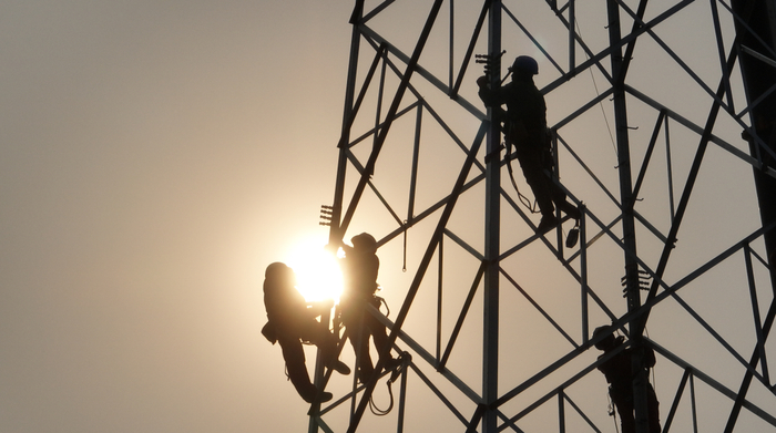 在十里牵引站220千伏外部供电工程现场，建设人员正在高空组塔。