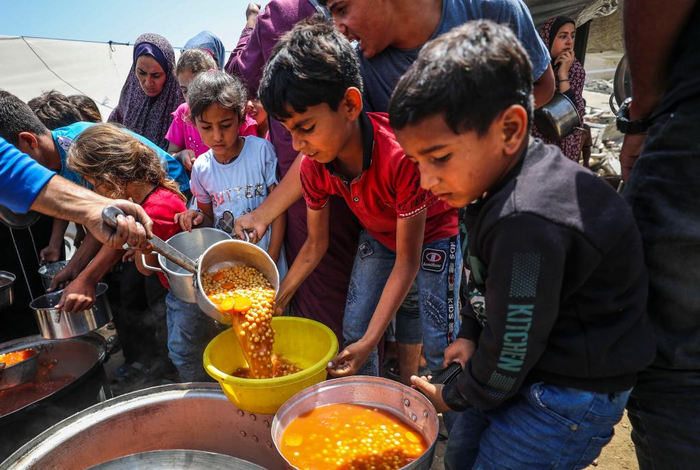 6月3日，巴勒斯坦人在加沙城领取食物。新华社发（马哈茂德·扎基摄）