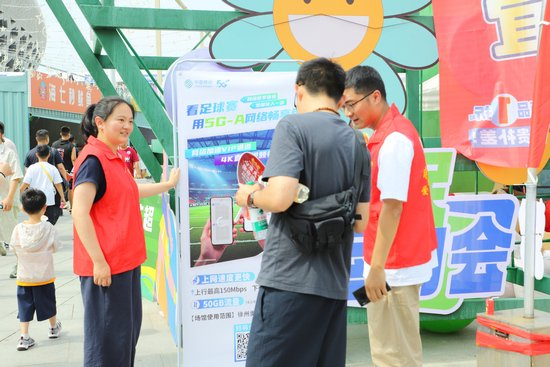 球迷在徐州奥体中心外了解“5G-A场馆畅享包”