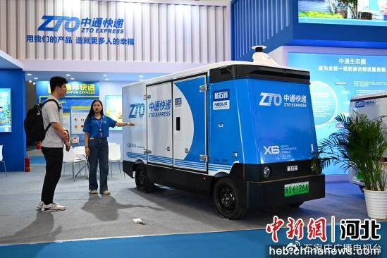 图为在2025年廊坊经洽会智慧物流技术与装备展区，中通快递工作人员正介绍一辆智能无人配送车。  赵永辉 摄