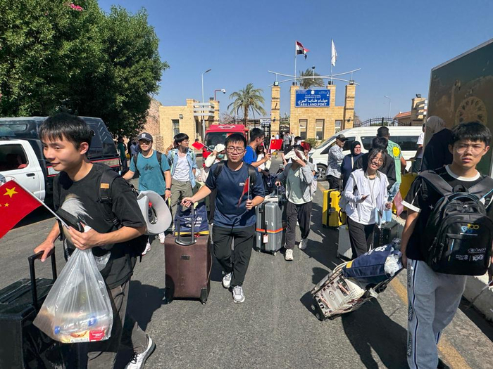 6月19日，从以色列撤离的中国公民从埃及南西奈省塔巴口岸进入埃及。新华社发（艾哈迈德·戈马 摄）