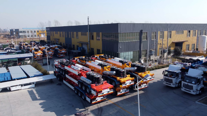 在建星专用车制造有限公司的厂区内，一批崭新的集装箱平板半挂车整装待发。（受访者供图）