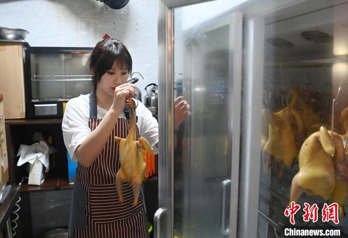 　　6月13日，林凤怡将鸡放进烤箱烤制。中新社记者 蒋雪林 摄