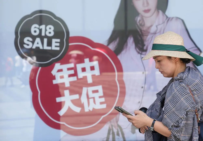 6月18日，行人经过浙江省杭州市一家商场的“618”海报。新华社记者 韩传号 摄