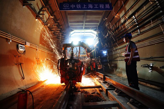 17号线中段今日实现了“长轨通”，工人正在操作机器焊接钢轨。 新京报记者 王贵彬 摄