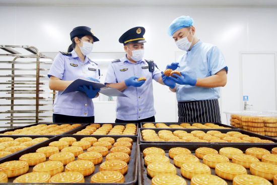 2023年9月25日，河北邯郸市，市场监督管理局执法人员对食品加工企业的月饼进行检查。图/中新