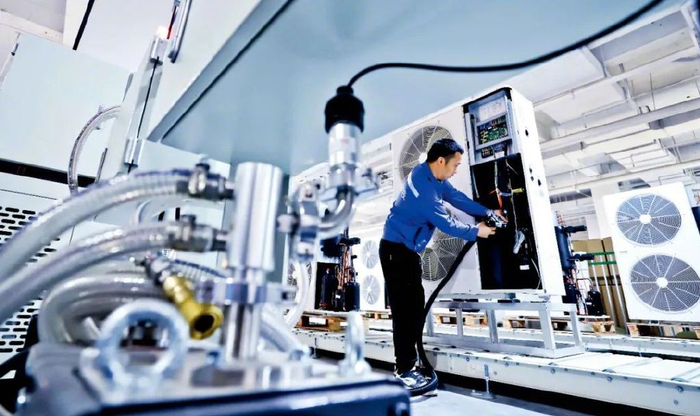 2024年6月7日，甘肃一条热泵机组生产线上，工作人员正在进行超低温变频空气源热泵机组的组装。图/视觉中国