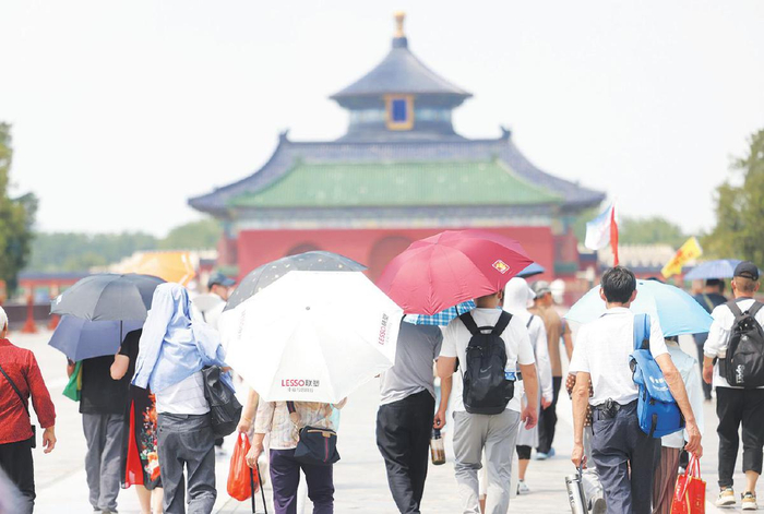 6月23日，天坛公园，游客打着伞在烈日下游览。　新京报记者　王贵彬　摄