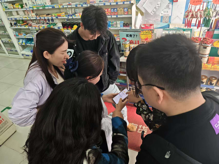 图注：美团员工向药店店员展示系统操作方法摄影：刘楠