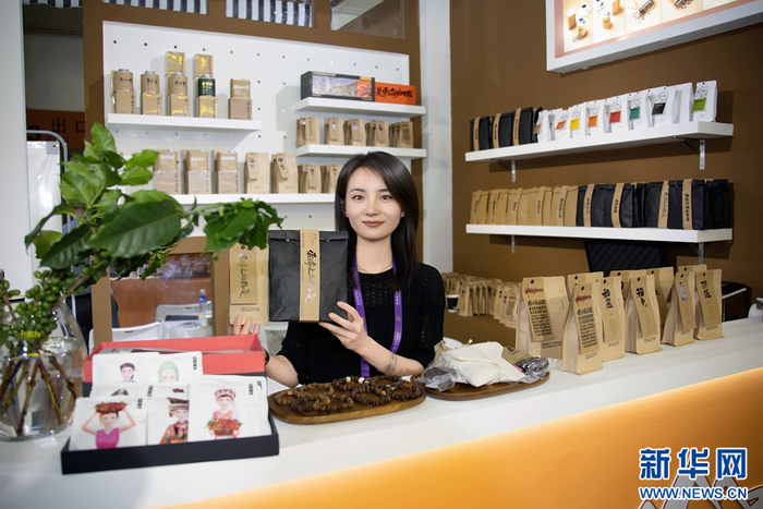 一名云南参展商展示瑰夏咖啡豆（摄于6月19日）。新华网发（陈畅 摄）