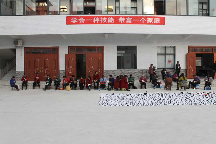 群众正在制作毛布底鞋。洪兰摄