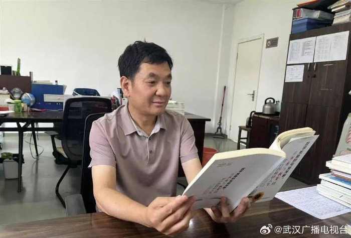 张胜言在办公室阅读教研书籍。