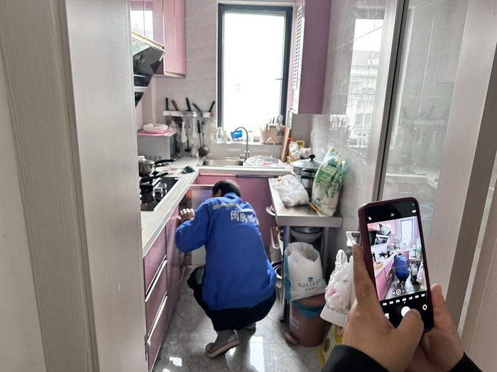 闵房物业人员为老人检查煤气管道。