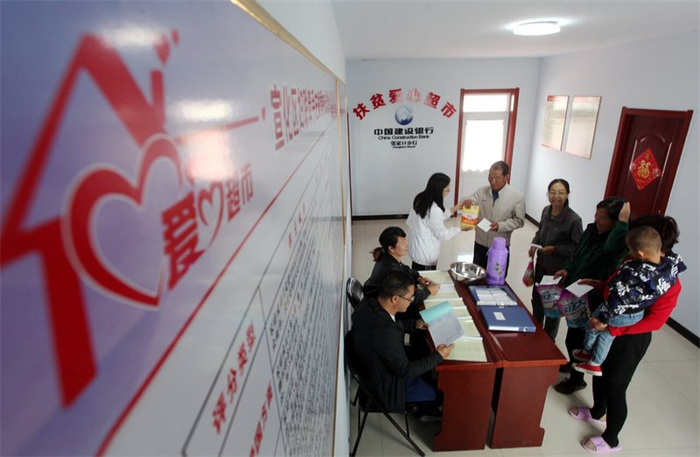 4月3日，在张家口市宣化区顾家营镇左家营村爱心超市，村民们正在用文明积分兑换日用品。 省文明办供图