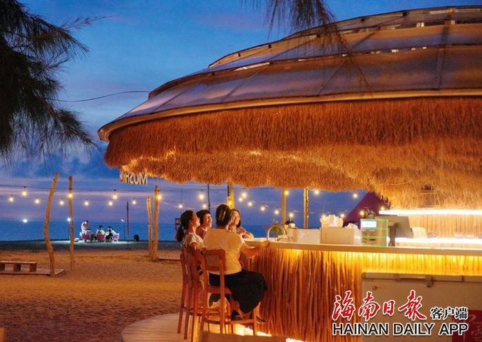 昌江沙渔塘社区的沙滩上，日暮西沉，晚霞绯红，游客们在海风的轻拂下，尽享宁静与惬意。海南日报全媒体记者 张茂 摄