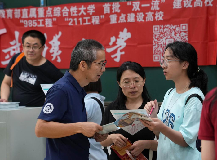 6月15日，考生（右）向武汉大学的招生老师咨询。新华社记者 刘颖 摄