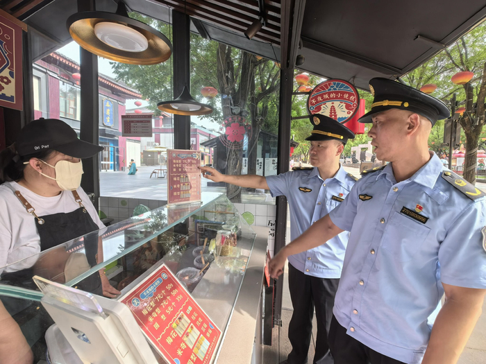 西安市市场监管局曲江新区分局大雁塔市场监管所的工作人员检查商户的价签是否规范。徐文智/摄