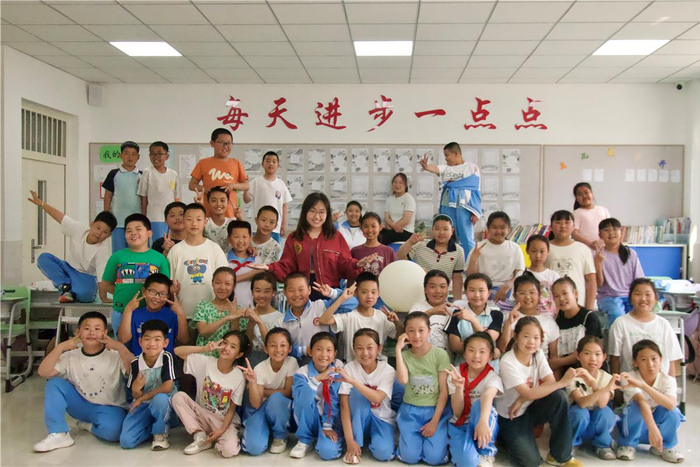 　　徐梓萌与兴安北京小学的小朋友合影。（资料图）