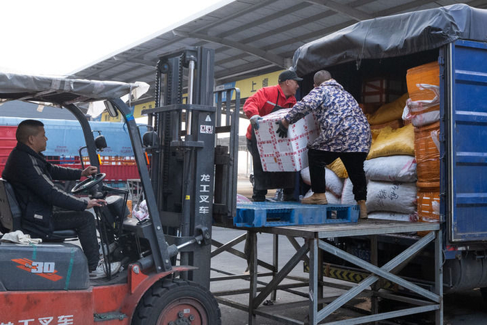 2024年1月5日，在湖北省潜江市的中国小龙虾交易中心，工人正在进行搬运作业。新华社记者肖艺九摄