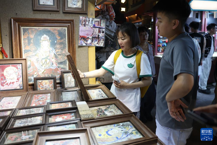 6月26日晚，游客在敦煌夜市选购特色商品。新华社记者陈斌摄