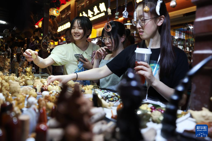 6月26日晚，游客在敦煌夜市选购特色商品。新华社记者陈斌摄