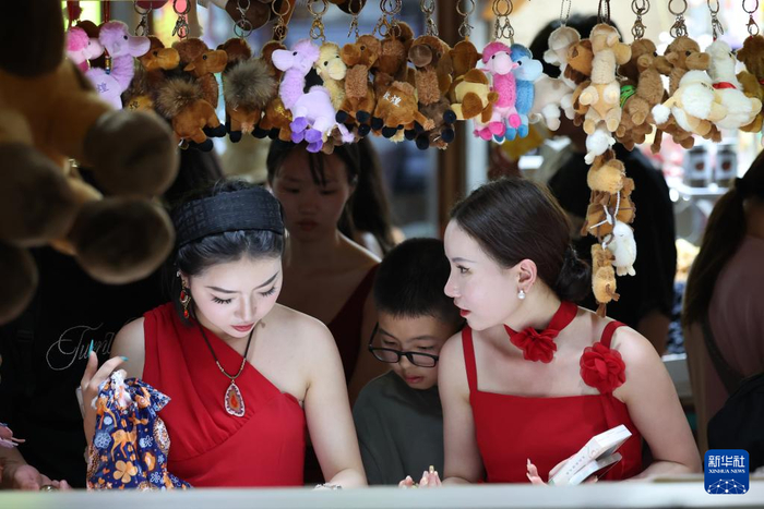 6月26日晚，游客在敦煌夜市选购特色商品。新华社记者陈斌摄