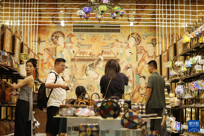 6月26日晚，游客在敦煌夜市选购特色商品。新华社记者陈斌摄