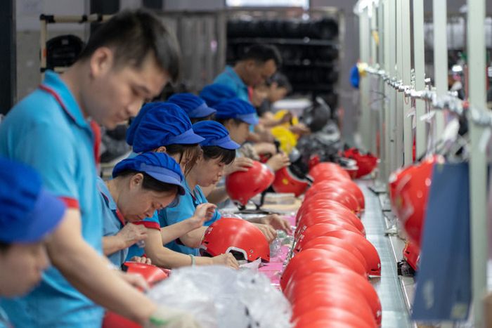 　　工人在溢联科技有限公司生产车间生产电动车头盔（6月17日摄）。新华社记者 郭杰文 摄