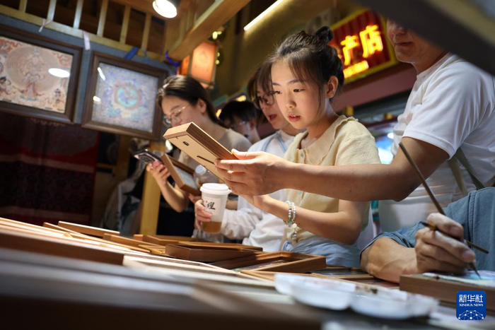 6月26日晚，游客在敦煌夜市选购特色商品。新华社记者陈斌摄