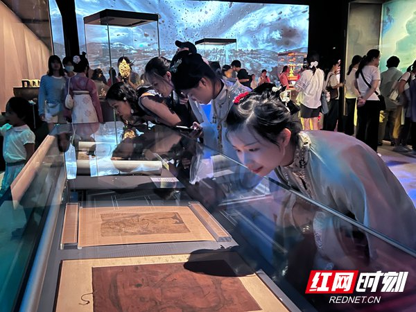 观众正在仔细观赏文物。