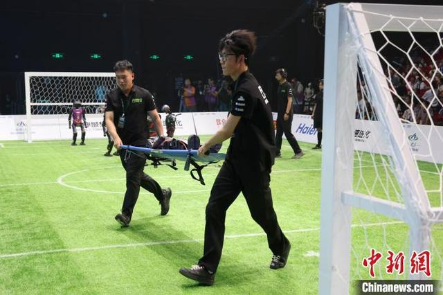 6月28日晚，2025RoBoLeague机器人足球联赛总决赛在北京打响。图为机器人倒地后被抬出赛场。中新社记者 富田 摄