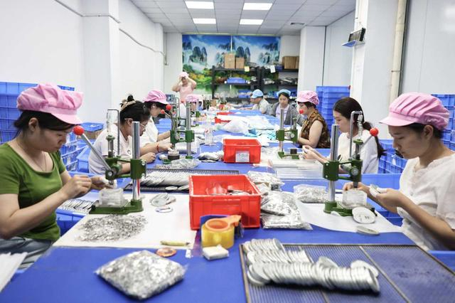 “栗汀”品牌的合作工厂内，员工紧锣密鼓制作吧唧。展钊|摄
